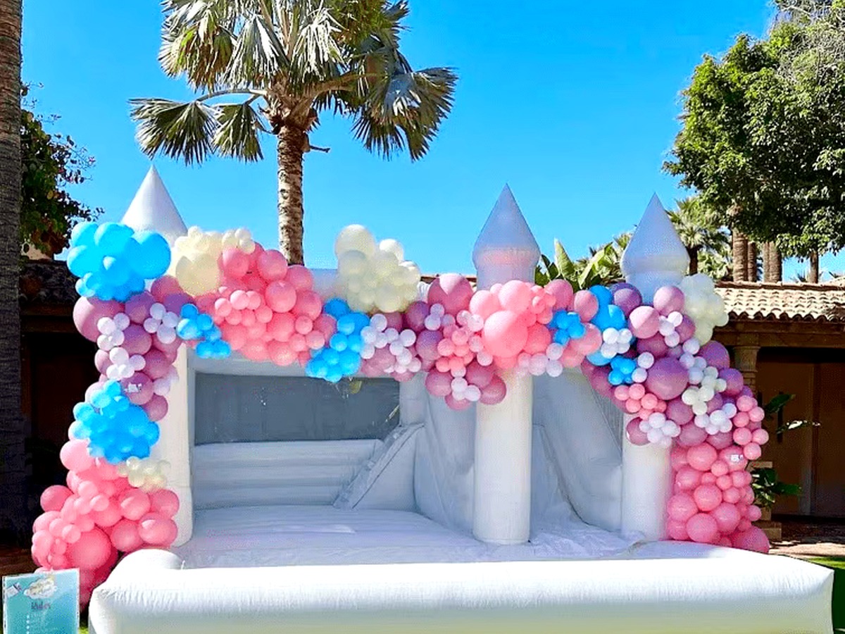 An elegant all-white Hartwell Inflatables castle bounce house with a classic bishop-top peak, styled as a centerpiece at an outdoor celebration in Columbia, South Carolina